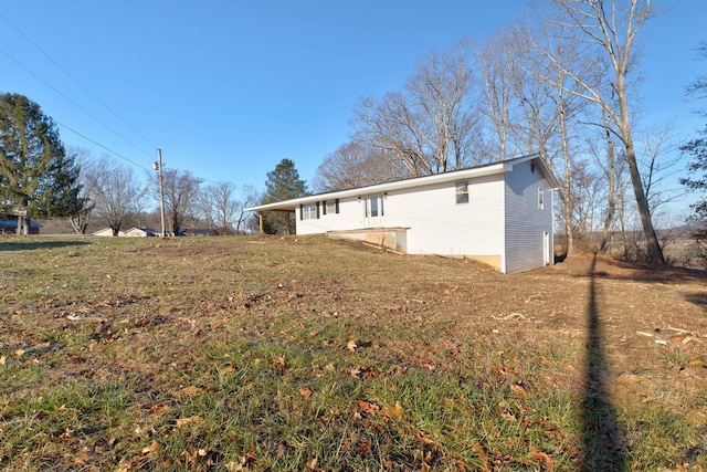 view of side of home with a yard