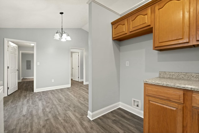 kitchen with pendant lighting, lofted ceiling, dark wood-type flooring, electric panel, and light stone counters