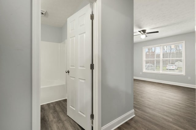 hallway featuring dark hardwood / wood-style flooring and a textured ceiling