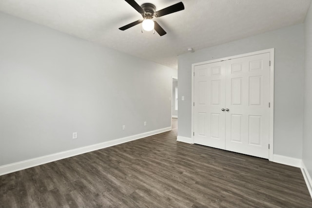 unfurnished bedroom featuring ceiling fan, dark hardwood / wood-style flooring, and a closet