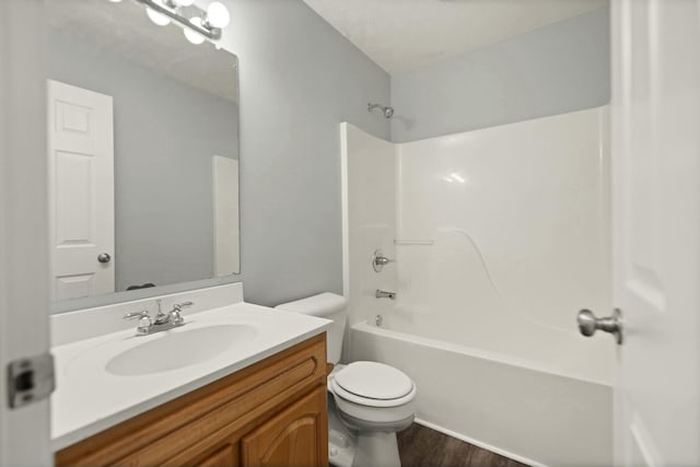 full bathroom featuring hardwood / wood-style floors, vanity, toilet, and shower / washtub combination