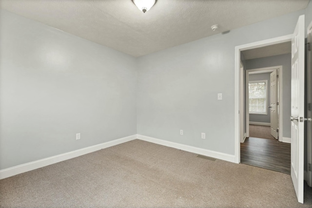 empty room with carpet flooring and a textured ceiling