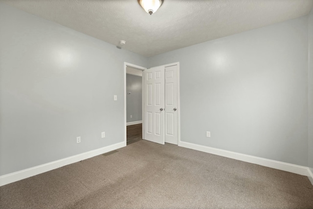 empty room featuring carpet and a textured ceiling