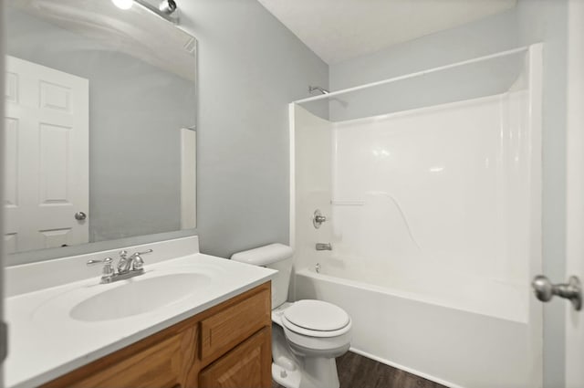 full bathroom with wood-type flooring, a textured ceiling, toilet, vanity, and bathtub / shower combination