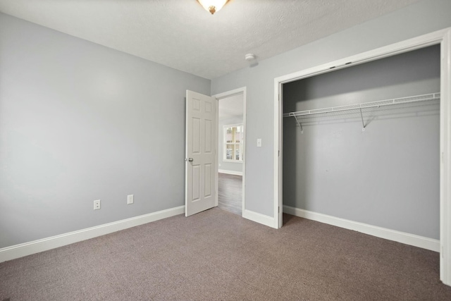 unfurnished bedroom with carpet flooring, a closet, and a textured ceiling