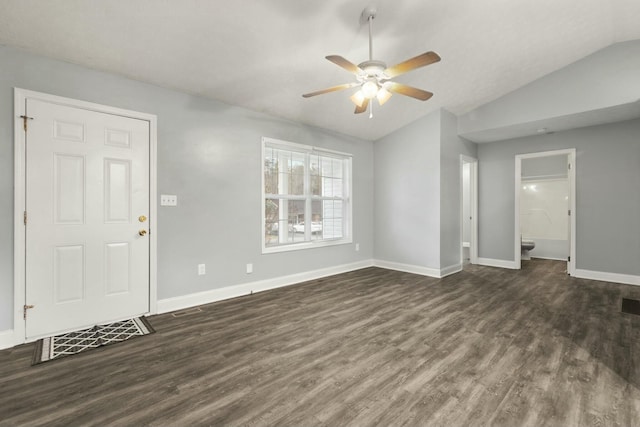 unfurnished living room with ceiling fan, dark wood-type flooring, and vaulted ceiling