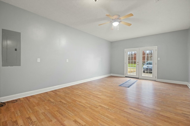 spare room with ceiling fan, light hardwood / wood-style floors, electric panel, and french doors