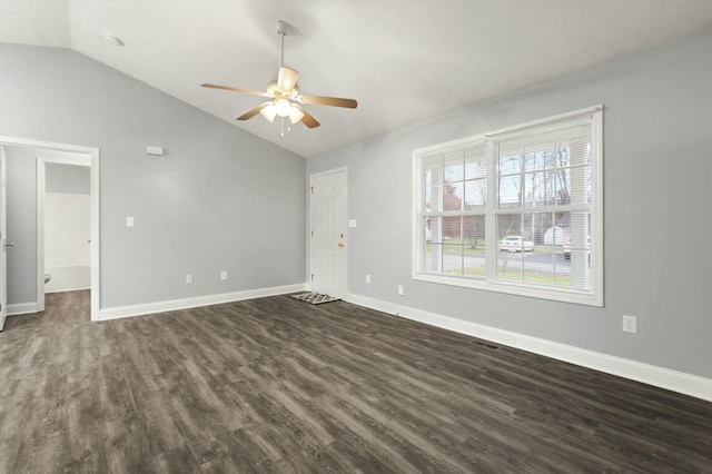 spare room with dark hardwood / wood-style flooring, vaulted ceiling, and ceiling fan