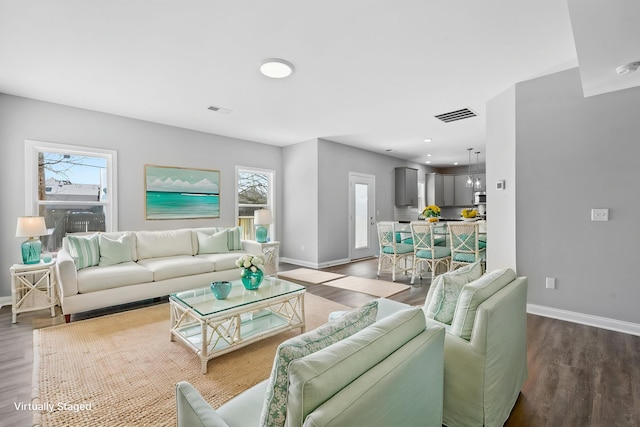 living room featuring visible vents, wood finished floors, and baseboards