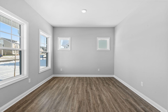 unfurnished room featuring dark wood-style flooring and baseboards
