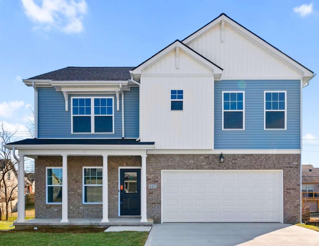 view of front of property with board and batten siding, a front yard, driveway, and an attached garage