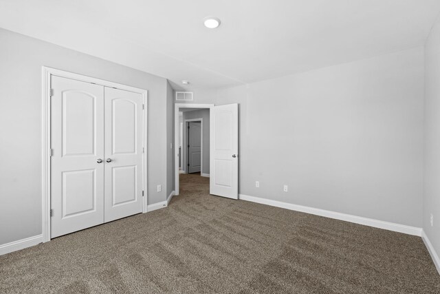 carpeted empty room featuring visible vents and baseboards