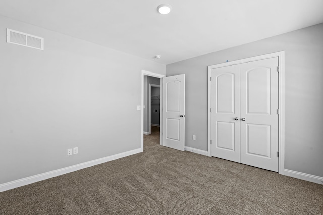 unfurnished bedroom featuring carpet, visible vents, a closet, and baseboards