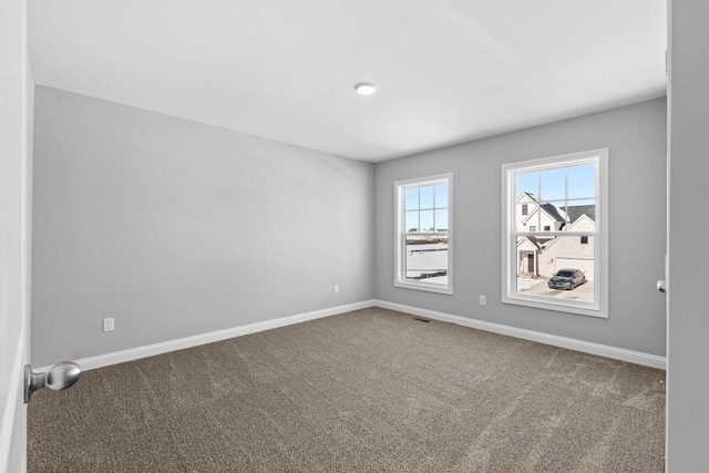 empty room with visible vents, baseboards, and carpet floors
