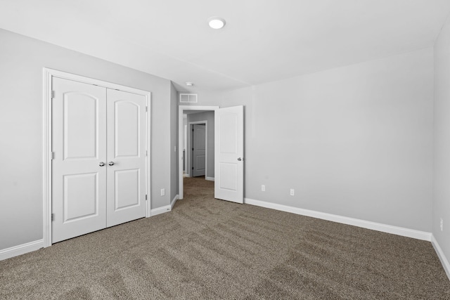 unfurnished bedroom featuring a closet, carpet flooring, visible vents, and baseboards