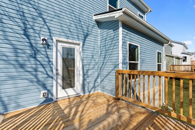 back of house featuring stairs, a lawn, and a wooden deck