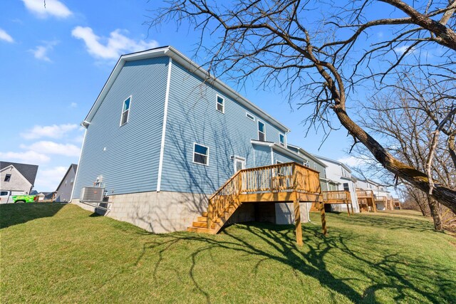 rear view of house with a lawn, a wooden deck, and stairs