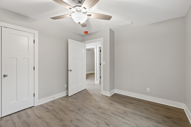 unfurnished bedroom with ceiling fan, a closet, and light wood-type flooring