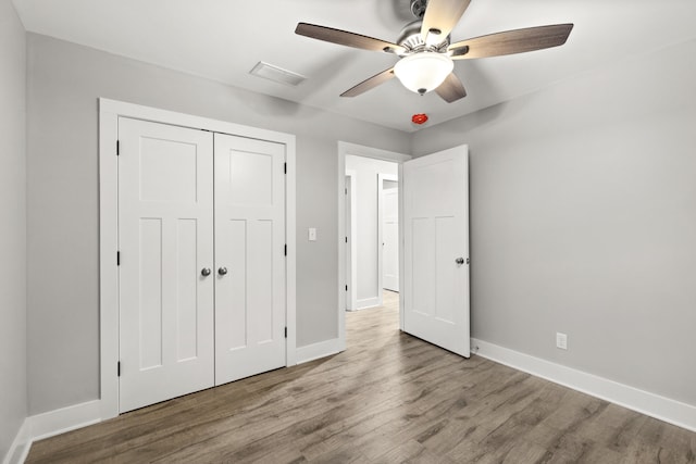 unfurnished bedroom featuring hardwood / wood-style flooring, ceiling fan, and a closet