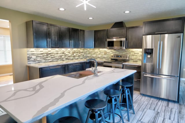 kitchen with a center island with sink, sink, and appliances with stainless steel finishes