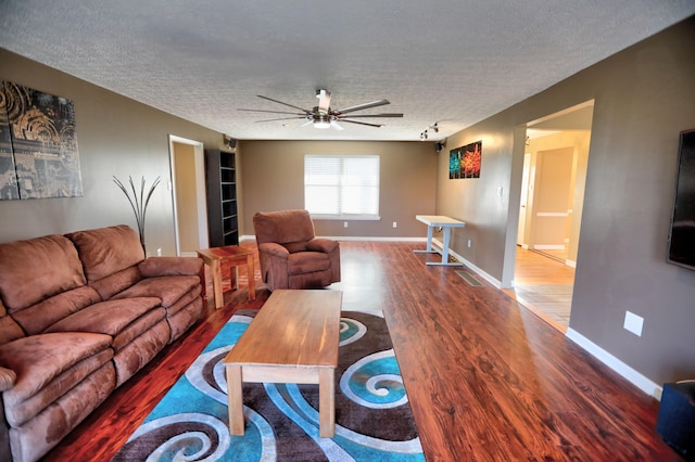 living room featuring ceiling fan, hardwood / wood-style floors, rail lighting, and a textured ceiling