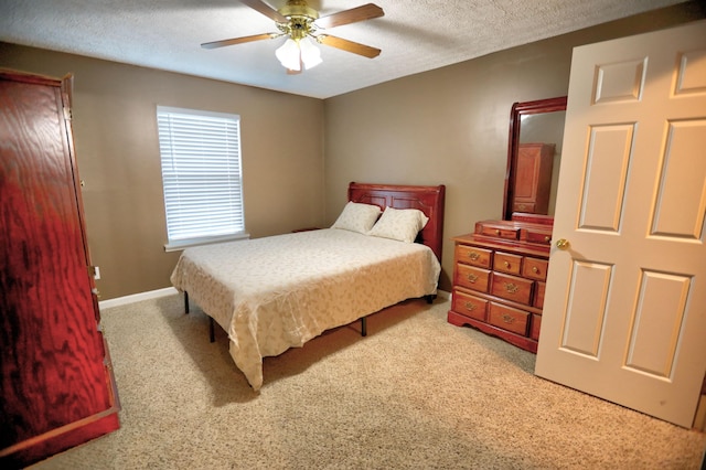 carpeted bedroom with ceiling fan and a textured ceiling