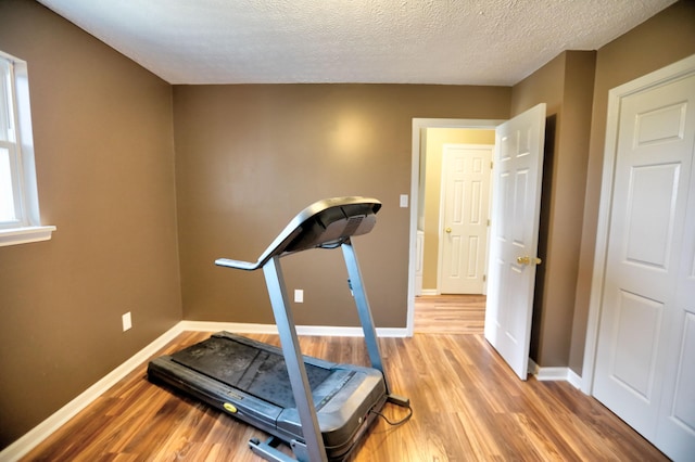 workout room with wood-type flooring and a textured ceiling