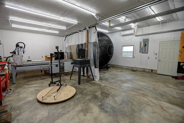 garage featuring electric panel and a wall mounted AC