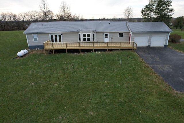 back house at dusk with a yard, a garage, and a deck