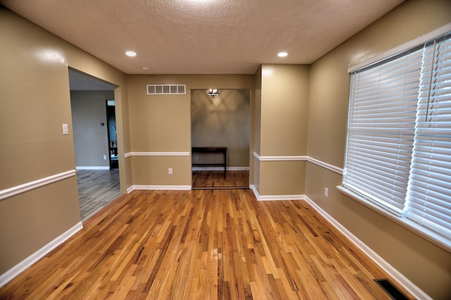 empty room featuring a textured ceiling and light wood-type flooring