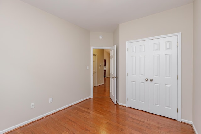 unfurnished bedroom with a closet and wood-type flooring