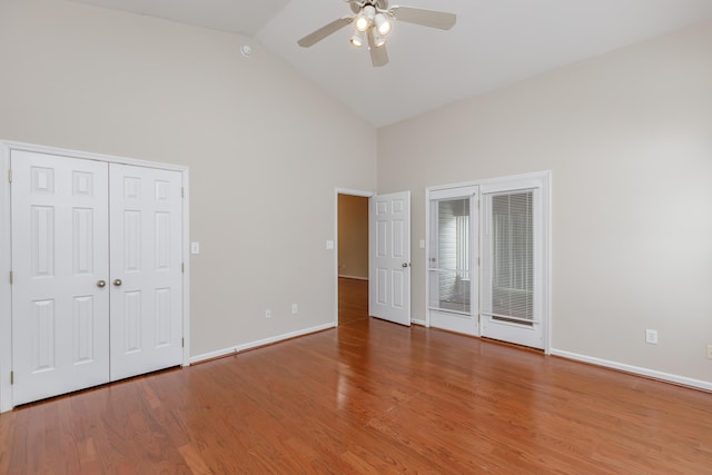 unfurnished bedroom featuring ceiling fan, wood-type flooring, and high vaulted ceiling