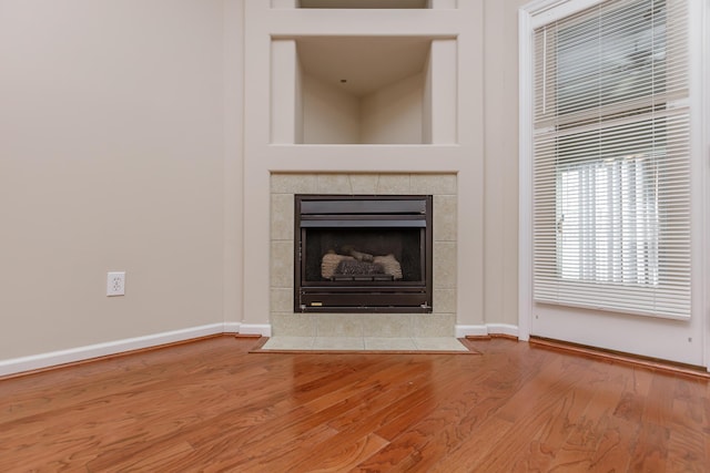 interior details featuring hardwood / wood-style floors and a tile fireplace