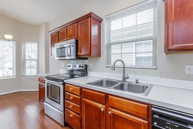 kitchen featuring stainless steel appliances, hardwood / wood-style flooring, and sink