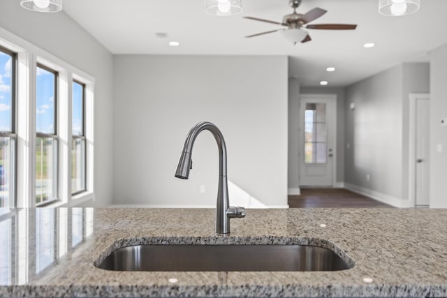 kitchen featuring light stone counters and sink