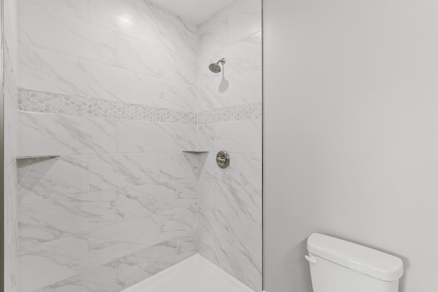 bathroom with tiled shower and toilet