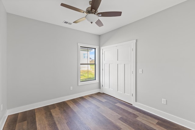 unfurnished bedroom featuring ceiling fan and dark hardwood / wood-style flooring