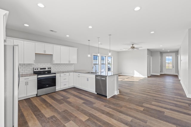 kitchen with sink, white cabinetry, stainless steel appliances, and hanging light fixtures