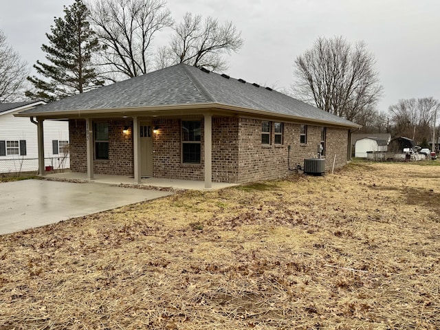 rear view of house with central AC and a patio area