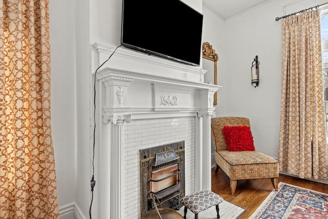 sitting room with hardwood / wood-style floors and ornamental molding