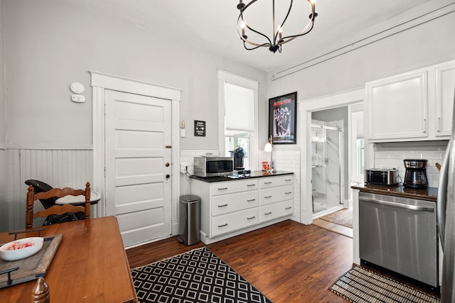 kitchen with dark hardwood / wood-style flooring, stainless steel appliances, decorative light fixtures, a notable chandelier, and white cabinetry