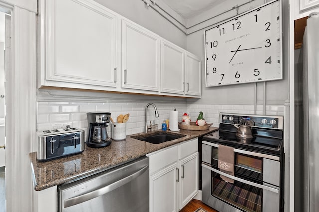 kitchen with appliances with stainless steel finishes, white cabinetry, and sink