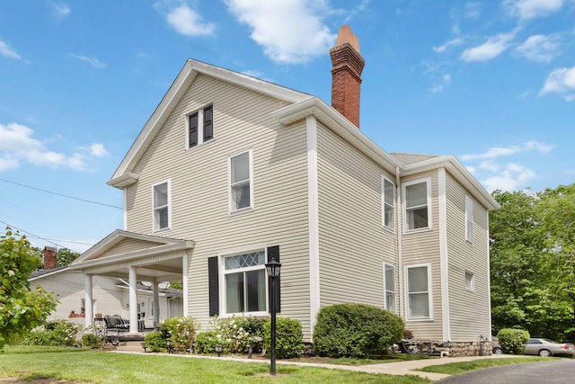 424 S 4th St, Danville, KY 40422 - view of property exterior featuring a chimney, a lawn, and covered porch