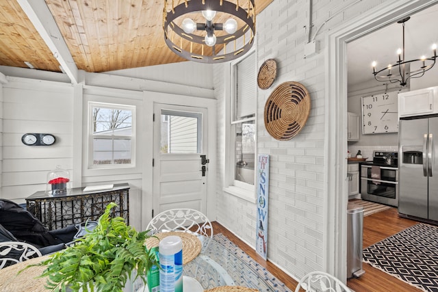 interior space featuring wood ceiling, lofted ceiling, and an inviting chandelier