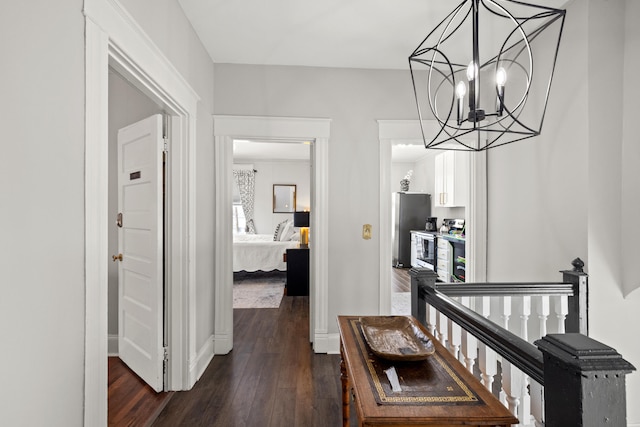 hall featuring dark hardwood / wood-style floors and a chandelier