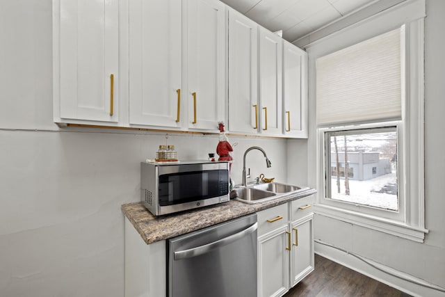 kitchen with white cabinets, sink, dark hardwood / wood-style floors, appliances with stainless steel finishes, and stone countertops