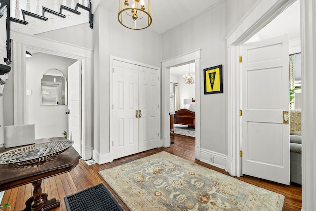 foyer entrance featuring dark hardwood / wood-style floors and a notable chandelier