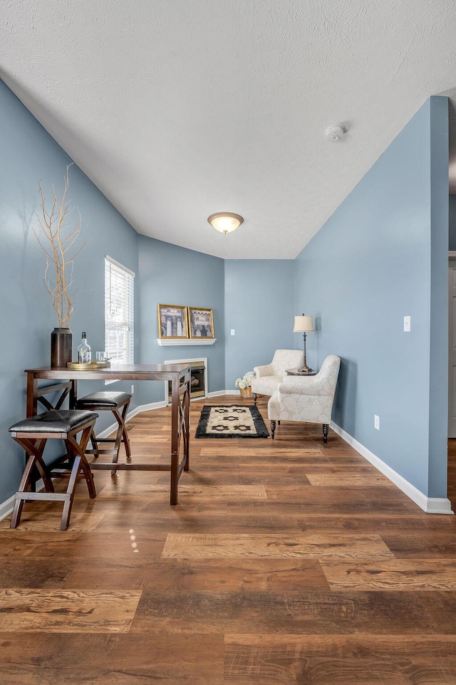 sitting room featuring a textured ceiling, baseboards, and wood finished floors