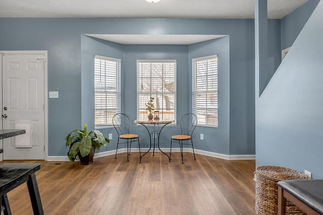 living area with baseboards and wood finished floors