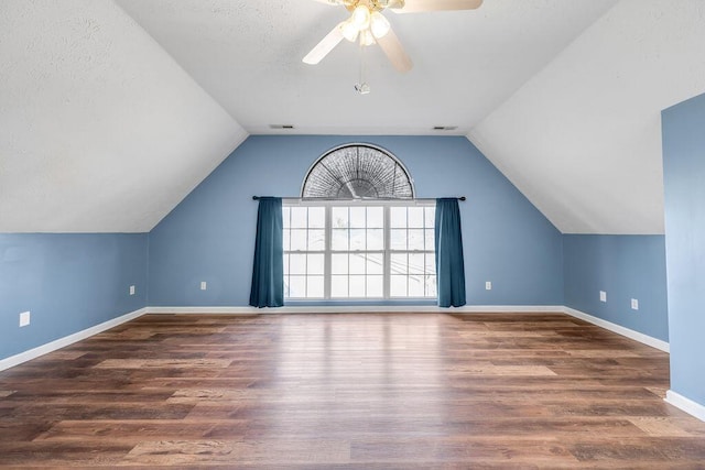 additional living space with lofted ceiling, baseboards, and dark wood-type flooring